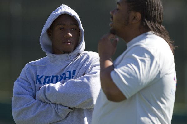 Injured Kansas receiver Daymond Patterson, left, talks with teammate Jeremiah Edwards during practice on Monday, April 11, 2011 at the practice fields near Memorial Stadium.