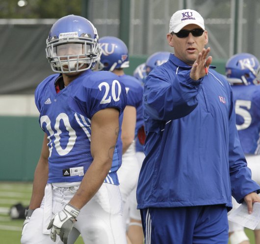 Kansas University wide receivers coach David Beaty, right, delivers instructions to KU wideout D.J. Beshears on April 18 at the KU practice field. Beaty rejoined the Jayhawks’ staff after serving as offensive coordinator at Rice last season.