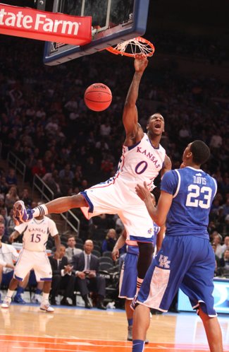 Kansas forward Thomas Robinson hangs on the rim after a dunk over Kentucky forward Anthony Davis during the first half on Tuesday, Nov. 15, 2011 at Madison Square Garden in New York.