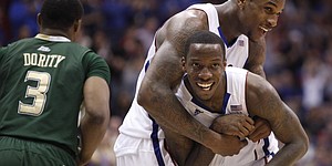Kansas forward Thomas Robinson, top, hugs teammate Tyshawn Taylor after Taylor's feed to Robinson for a dunk against South Florida during the second half on Saturday, Dec. 3, 2011 at Allen Fieldhouse.