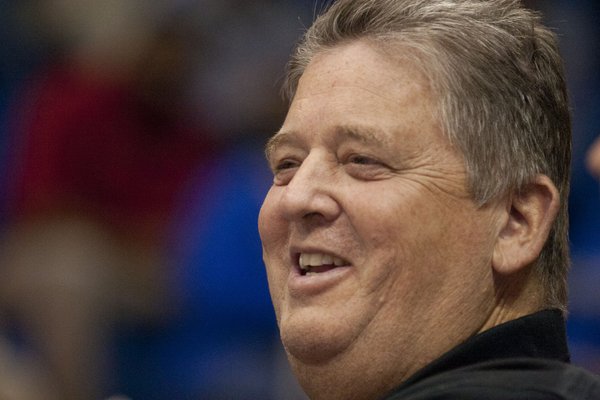 New Kansas football coach Charlie Weis smiles from the sideline during the KU women's basketball team's game against Kansas State at Allen Fieldhouse. The Jayhawks fell to the Wildcats, 63-57.