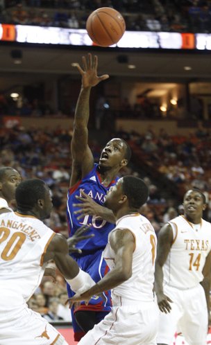 Kansas guard Tyshawn Taylor tosses up a lob over the Texas defense for teammate Thomas Robinson during the first half on Saturday, Jan. 21, 2012 at the Frank Erwin Center.