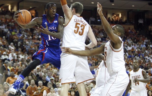 Kansas guard Tyshawn Taylor hooks around Texas big men Clint Chapman (53) and Jonathan Holmes (10) for a pass during the second half on Saturday, Jan. 21, 2012 at the Frank Erwin Center.