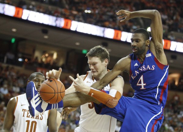 Kansas forward Justin Wesley wrestles for a loose ball with Texas center Clint Chapman during the second half on Saturday, Jan. 21, 2012 at the Frank Erwin Center.