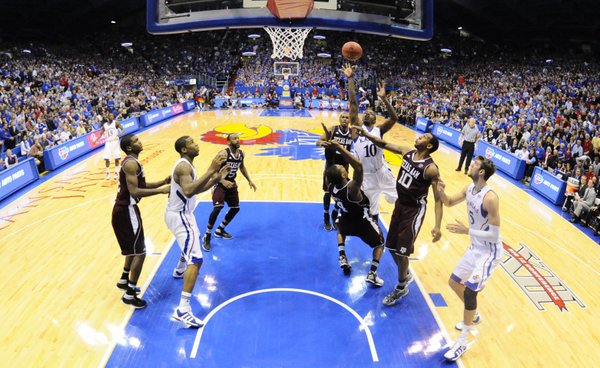 Kansas guard Tyshawn Taylor is fouled as he lofts a shot over Texas A&M forward Keith Davis during the second half on Monday, Jan. 23, 2012 at Allen Fieldhouse.