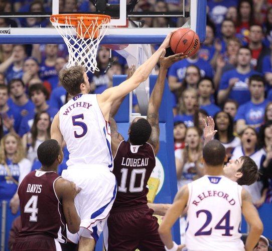 Kansas center Jeff Withey stuffs a shot by Texas A&M forward David Loubeau during the second half on Monday, Jan. 23, 2012 at Allen Fieldhouse.