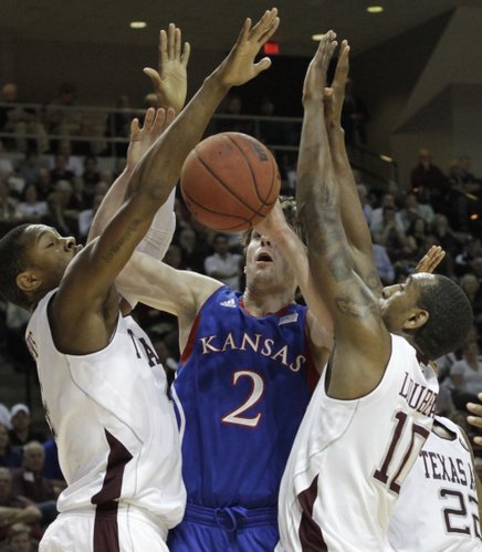 Kansas guard Conner Teahan gets caught between defenders beneath the basket during the first half of the Jayhawks' game against Texas A&M on Wednesday, Feb. 22, 2012, in College Station, Texas.