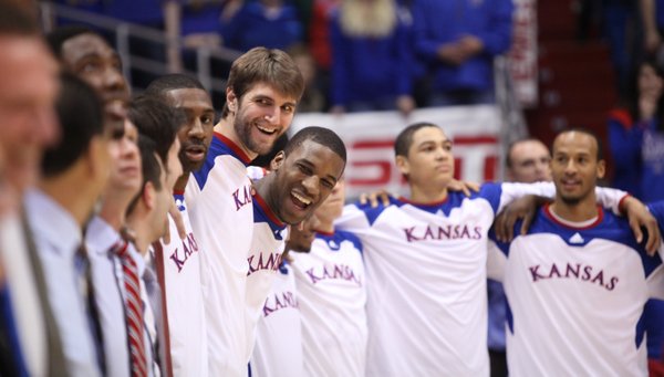 Kansas center Jeff Withey and forward Thomas Robinson laugh with their teammates and coaches as they huddle together for the Alma Mater on Saturday, March 3, 2012 at Allen Fieldhouse.