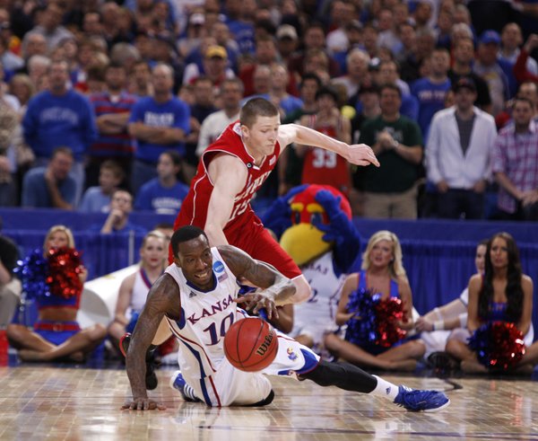 Kansas guard Tyshawn Taylor regains possession as North Carolina State forward Scott Wood defensds late in the second half on Friday, March 23, 2012 at the Edward Jones Dome in St. Louis.