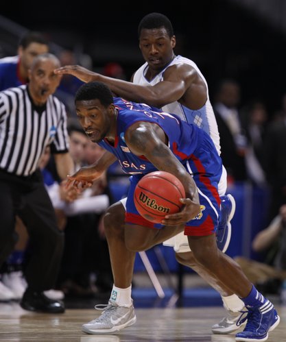 Kansas guard Elijah Johnson comes away with a steal from North Carolina forward Harrison Barnes during the first half on Sunday,  March 25, 2012 at the Edward Jones Dome in St. Louis.