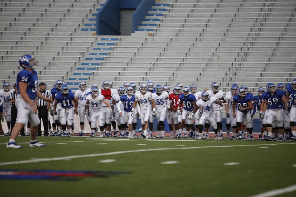 The Jayhawks rush the field as they watch a field goal from kicker Ron Doherty to end practice on Thursday, April 19, 2012 at Memorial Stadium.