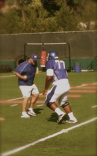KU lineman Aslam Sterling, the team's starting right guard, runs through a drill with O-Line coach Tim Grunhard during Tuesday's practice. 