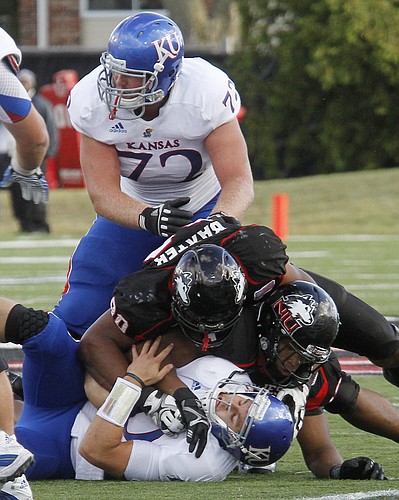 Dayne Crist (10) is sacked in the second half of KU's 30-23 loss to Northern Illinois Huskies Saturday, September 22, 2012, at Huskie Stadium in DeKalb, Ill. At top is left tackle Tanner Hawkinson.