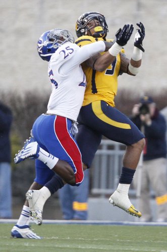 Kansas cornerback JaCorey Shepherd (25) wraps up Mountaineer receiver Stedman Bailey (3) before the ball reached him in the second half of KU's 59-10 loss Saturday against West Virginia University in Morgantown, W.Va. Shepherd was called for pass interference on the play.
