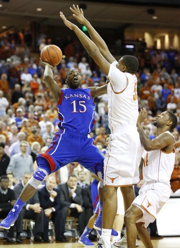 Kansas guard Elijah Johnson is defended by Texas players Cameron Ridley, left, and Julien Lewis during the first half on Saturday, Jan. 19, 2013 at Frank Erwin Center in Austin, Texas.