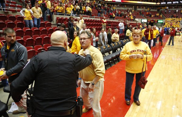 An Iowa State fan is restrained by police after charging at Kansas head coach Bill Self after the Jayhawks' 108-96 overtime win on Monday, Feb. 25, 2013 at Hilton Coliseum in Ames, Iowa.