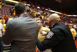 An Iowa State fan is restrained by police after charging at Kansas head coach Bill Self after the Jayhawks' 108-96 overtime win on Monday, Feb. 25, 2013 at Hilton Coliseum in Ames, Iowa.