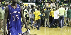 Elijah Johnson (15) leaves the court as Baylor fans surround Baylor players at half court after KU's 81-58 loss to the Baylor Bears Saturday in Waco.