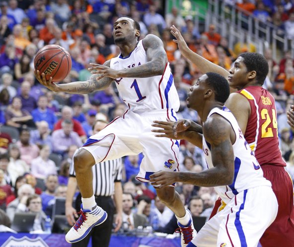Kansas guard Naadir Tharpe hangs for a shot past Iowa State center Percy Gibson and teammate Jamari Traylor during the first half of the semifinal round of the Big 12 tournament on Friday, March 15, 2013 at the Sprint Center in Kansas City, Missouri.