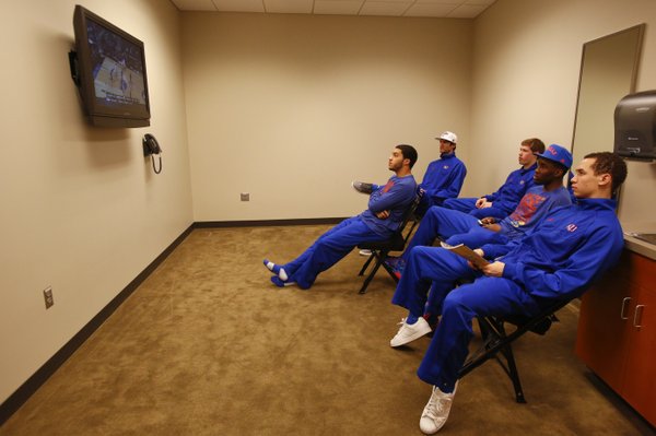 Several of the Jayhawks watch the Oklahoma State v. Oregon game as other members of the team take questions from media members in the locker room on Thursday, March 22, 2013 at the Sprint Center in Kansas City, Mo.