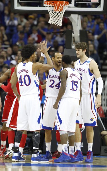 Kansas guard Travis Releford slaps hands with his teammates after drawing a foul on a bucket during the first half on Friday, March 22, 2013 at the Sprint Center in Kansas City, Mo.