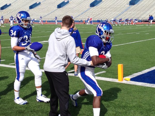 KU running back Tony Pierson takes a handoff from Charlie Weis Jr., during Tuesday's practice at Memorial Stadium. 