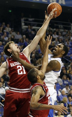 Kentucky's Terrence Jones, right, puts up a shot under pressure from Arkansas' Hunter Mickelson (21) and Marvell Waithe during the first half of an NCAA college basketball game in Lexington, Ky., Tuesday, Jan. 17, 2012.