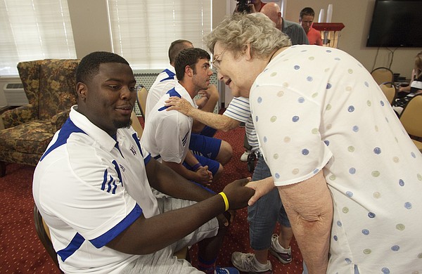 Richard Gwin/Journal World Photo.KU football player Marquel Combs, shakes hands with resident Rose Tare-Smith, as a handful of KU football players were on hand at the Meadowlark Estates Retirement Home at 4430 Bauer Farm Drive to get some first hand information on KU football
