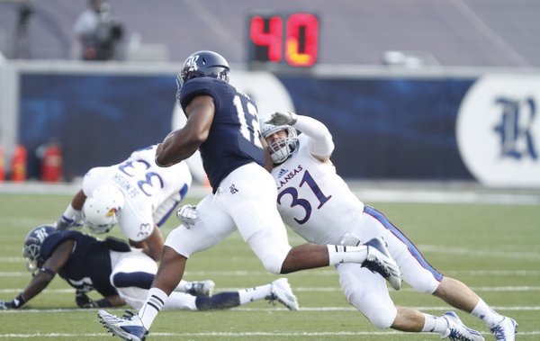 Kansas linebacker Ben Heeney reaches for Rice running back Charles Ross during the first quarter on Saturday, Sept. 14, 2013 at Rice Stadium in Houston, Texas.