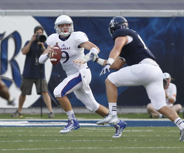 Kansas quarterback Jake Heaps is chased down by Rice defensive end Tanner Leland during the first quarter on Saturday, Sept. 14, 2013 at Rice Stadium in Houston, Texas.