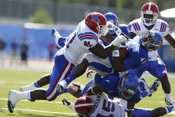 Kansas tight end Jimmay Mundine gets layed out after a catch by Louisiana Tech defensive lineman I.K. Enemkpali during the second quarter on Saturday, Sept. 21, 2013 at Memorial Stadium.