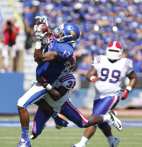 Kansas receiver Christian Matthews hauls in a pass with Louisiana Tech defensive back Xavier Woods on his back during the fourth quarter.