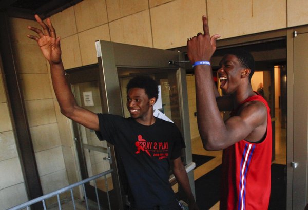 Kansas newcomers Andrew Wiggins, left, and Joel Embiid peek outside to pump up the crowd before the fieldhouse doors opened for Late Night in the Phog, Friday, Oct. 4, 2013.