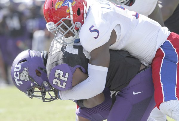 Kansas safety Isiah Johnson (5) gets all over TCU's Aaron Green (22) during a tackle in the second half on Saturday, Oct. 12, 2013.