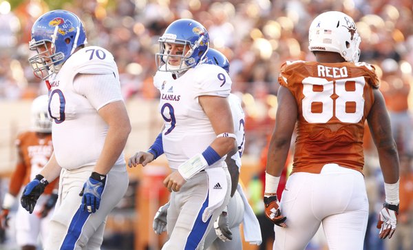 Kansas quarterback Jake Heaps bemoans a missed opportunity in the fourth quarter as he heads off the field with offensive lineman Gavin Howard after being sacked by the Texas defense during the fourth quarter on Saturday, Nov. 2, 2013 at Darrell K. Royal Stadium in Austin, Texas.