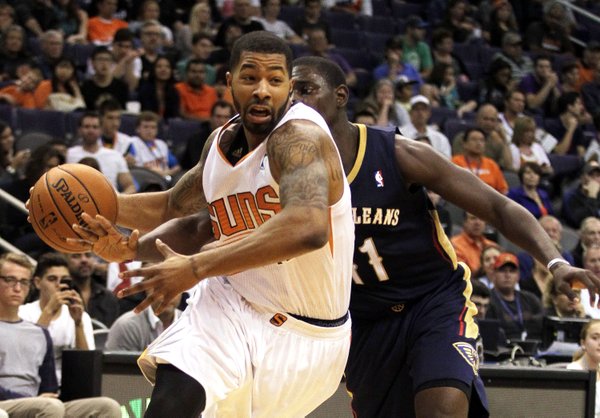 Phoenix Suns forward Markieff Morris, left, drives past New Orleans Pelicans guard Jrue Holiday, right, in the third quarter during an NBA basketball game on Sunday, Nov. 10, 2013, in Phoenix. The Suns defeated the Pelicans 101-94. (AP Photo/Rick Scuteri) 
