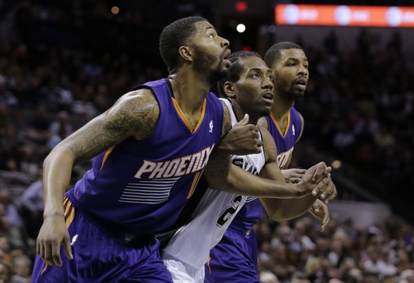 San Antonio Spurs' Kawhi Leonard, center, is boxed in by Phoenix Suns' Markieff Morris, left, and Marcus Morris, right, during the first half of an NBA basketball game, Wednesday, Nov. 6, 2013, in San Antonio. (AP Photo/Eric Gay)
