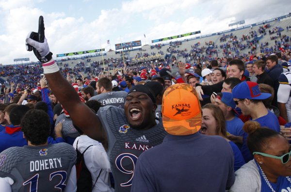 Kansas defensive lineman Keon Stowers celebrates with the fans on the field following the Jayhawks' 31-19 win over West Virginia on Saturday, Nov. 16, 2013 at Memorial Stadium.