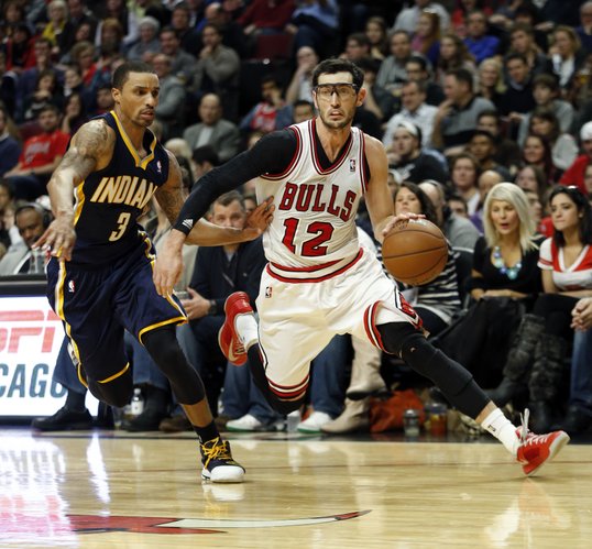 Chicago Bulls guard Kirk Hinrich (12) drives to the basket against Indiana Pacers guard George Hill (3) during the second half of an NBA basketball game in Chicago, Saturday, Nov. 16, 2013. The Bulls won 110-94. (AP Photo/Kamil Krzaczynski)
