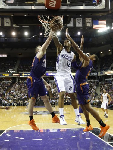 Sacramento Kings guard Ben McLemore, left, stuffs against Phoenix Suns' Miles Plumlee, center and Channing Frye during the third quarter of an NBA basketball game in Sacramento, Calif., Tuesday, Nov. 19, 2013. The Kings won 107-104.(AP Photo/Rich Pedroncelli) 