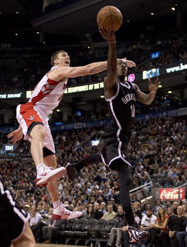 Brooklyn Nets guard Tyshawn Taylor (10) drives to the hoop past Toronto Raptors forward Tyler Hansbrough (left) during the second half of an NBA basketball game in Toronto on Tuesday, Nov. 26, 2013. (AP Photo/The Canadian Press, Frank Gunn)