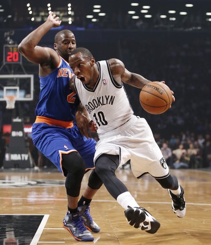 Brooklyn Nets guard Tyshawn Taylor (10) drives past New York Knicks guard Raymond Felton (2) in the first half of their NBA basketball game at the Barclays Center, Thursday, Dec. 5, 2013, in New York. (AP Photo/Kathy Willens)
