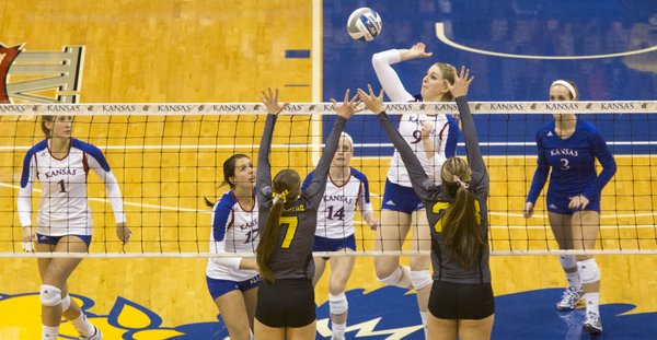 Kansas' Caroline Jarmoc (9) hits a spike past Wichita State's Ashley Andrade (28) and Katie Reilly (7) during their volleyball match in the first round of the NCAA tournament at Allen Fieldhouse. The Jayhawks defeated the Shockers, 3-1, and will face Creighton Saturday at 6:30 p.m.