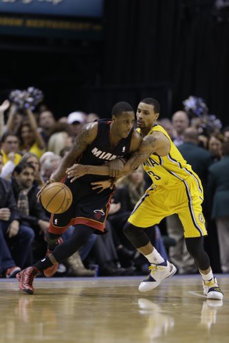 Indiana Pacers guard George Hill, right, defends Miami Heat guard Mario Chalmers in the second half of an NBA basketball game in Indianapolis, Tuesday, Dec. 10, 2013. The Pacers defeated the Heat 90-84. (AP Photo/Michael Conroy) 