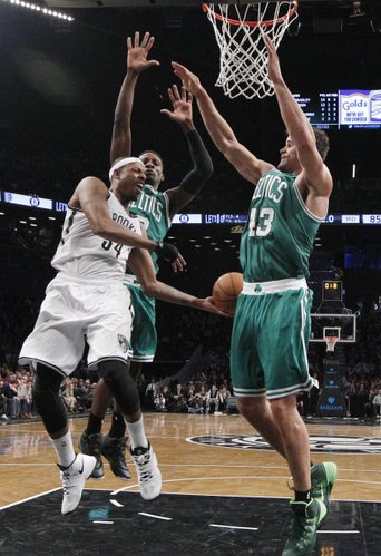 Boston Celtics guard Jeff Green (8) and Celtics forward Kris Humphries (43) defend Brooklyn Nets forward Paul Pierce (34) in the second half of their their NBA basketball game, Tuesday, Dec. 10, 2013, in New York. The Nets defeated the Celtics 104-96. (AP Photo/Kathy Willens) 