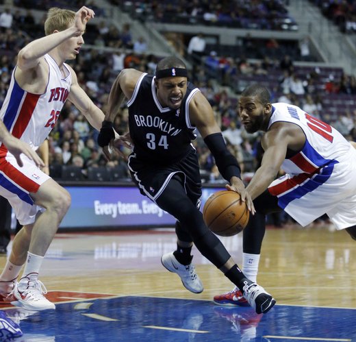 Brooklyn Nets forward Paul Pierce (34) drives to the basket between Detroit Pistons guard Kyle Singler (25) and center Greg Monroe (10) during the first half of an NBA basketball game on Friday, Dec. 13, 2013, in Auburn Hills, Mich. (AP Photo/Duane Burleson)