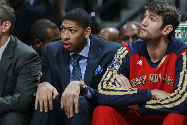 New Orleans Pelicans forward Anthony Davis, left, who is injured, sits on bench with rookie center Jeff Withey as the Pelicans face the Denver Nuggets in the first quarter of an NBA basketball game in Denver on Sunday, Dec. 15, 2013. (AP Photo/David Zalubowski)