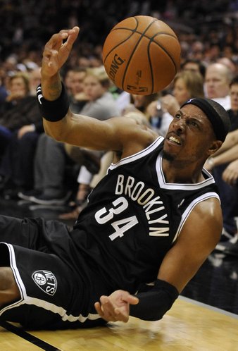 Brooklyn Nets forward Paul Pierce slides out of bounds as he chases the loose ball during the first half of an NBA basketball game against the San Antonio Spurs on Tuesday, Dec. 31, 2013, in San Antonio. (AP Photo/Darren Abate)