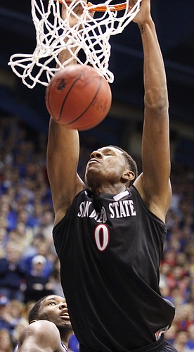 San Diego State forward Skylar Spencer finishes a dunk before Kansas center Joel Embiid during the second half on Sunday, Jan. 5, 2013 at Allen Fieldhouse.