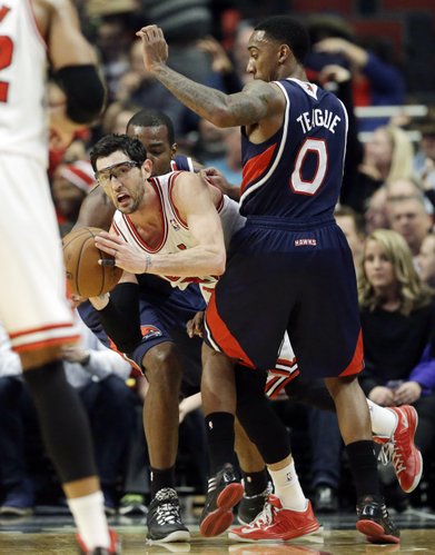 Chicago Bulls guard Kirk Hinrich, center, looks to pass as Atlanta Hawks forward Paul Millsap, left, and guard Jeff Teague guard during the first half of an NBA basketball game in Chicago on Saturday, Jan. 4, 2014. (AP Photo/Nam Y. Huh)